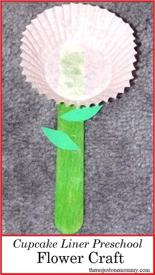 PreK flower craft made with glue, construction paper leaves, a popsicle stick stem, and a pink flower made from a cupcake liner.