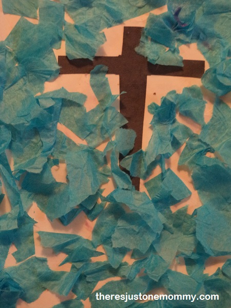 Cross craft for preschoolers using blue tissue paper and a cross made from brown construction paper.